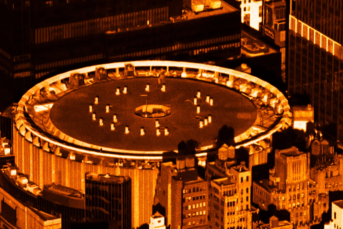 Aerial view of Madison Square Garden's circular rooftop among city buildings in orange duotone
