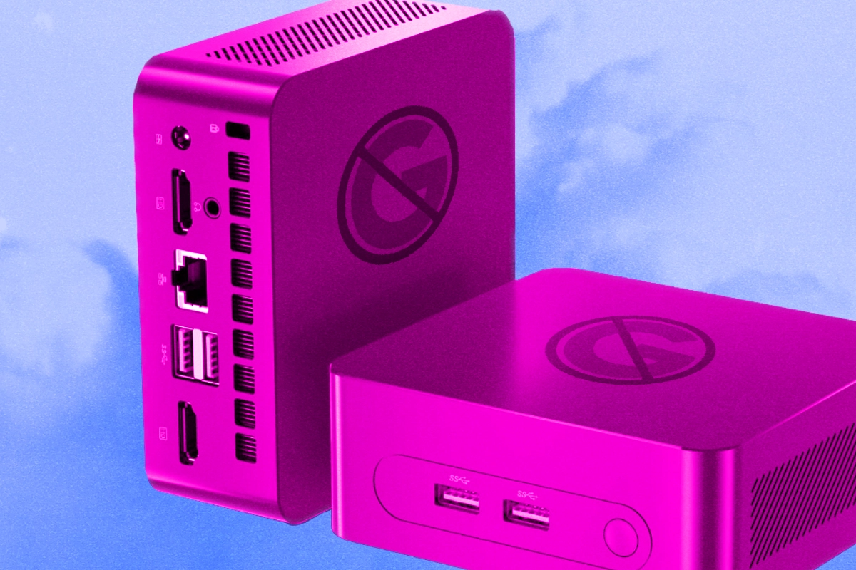 A small mini PC with status lights sitting on a wooden shelf next to a router in a home office